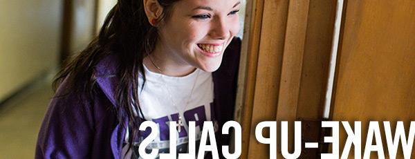 college student standing in a doorway smiling